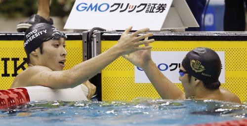 日本学生水泳選手権男子４００メートル個人メドレーで２連覇し、２位の早大・瀬戸大也（右）と健闘をたたえ合う東洋大・萩野公介