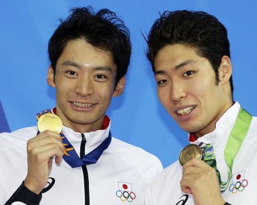 競泳男子２００メートル背泳ぎで３連覇を果たし、笑顔で金メダルを手にする入江陵介。右は銅メダルの萩野公介