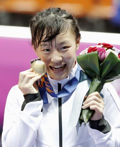 女子48キロ級で優勝し、表彰式で金メダルを手に笑顔の登坂