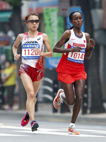 アジア大会女子マラソン　中間点を過ぎた付近でバーレーンのキルワ（右）とトップを並走する木崎良子
