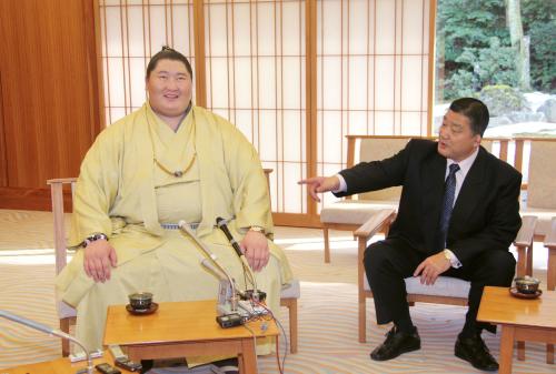 鳥取城北高相撲部の石浦外喜義監督（右）から激励を受け、笑顔を見せる逸ノ城