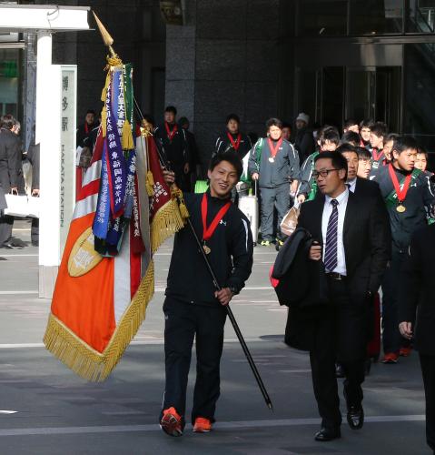 優勝旗を手に博多駅に到着した古川主将（左）、藤田監督（右）ら東福岡ラグビー部