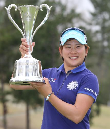 ＜スタジオアリス女子オープン最終日＞優勝を決めた成田美寿々はカップを掲げ笑顔をみせる