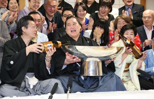 伊勢ケ浜親方（左）とおかみさんの淳子さん（右）にお酒を注がれ笑顔を見せる照ノ富士