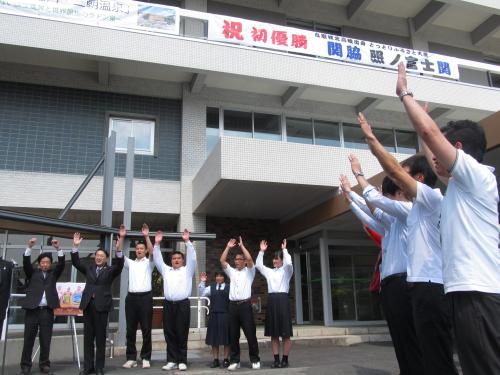鳥取県庁に掲げられた照ノ富士初優勝を祝う横断幕の前で、万歳をする鳥取城北高相撲部生徒ら
