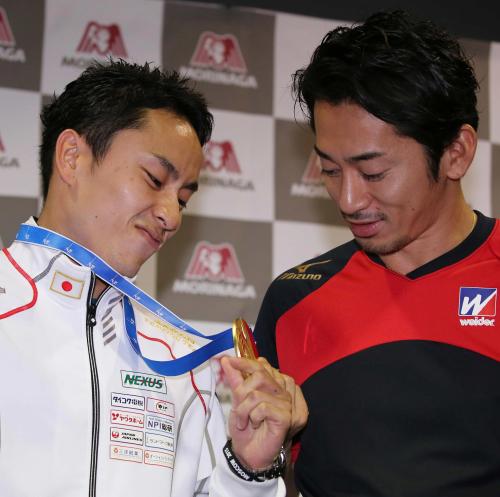 牧野トレーナー（右）に金メダルを見せ満足げな表情の太田
