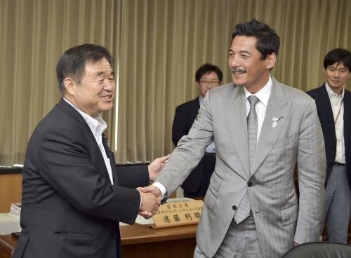 会談前に握手を交わす、遠藤五輪相（左）と平尾誠二氏