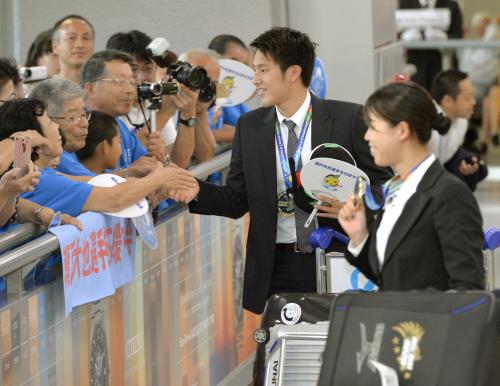 帰国し、出迎えた人たちに応える競泳の日本代表の瀬戸大也（左）と星奈津美