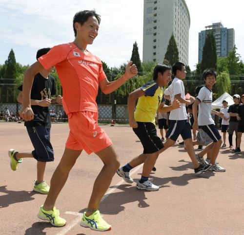 北京市内の日本人学校を訪問し、小中学生と交流する男子20キロ競歩代表の鈴木雄介（手前）