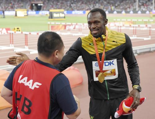 男子２００メートル決勝後に接触したカメラマン（左）の謝罪をうけ、肩をたたくウサイン・ボルト