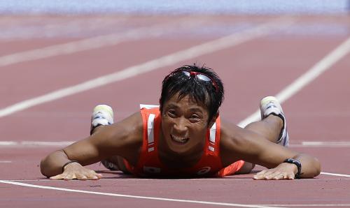 男子50キロ競歩で３位でゴールし、笑顔で倒れ込む谷井孝行（ＡＰ）