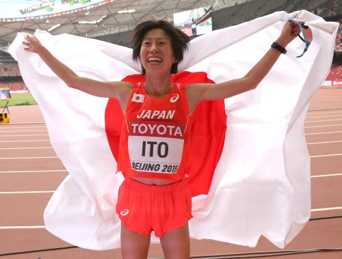 女子マラソンで７位でゴールし日の丸を背に笑顔を見せる伊藤