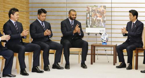 ラグビー日本代表の（左から）五郎丸歩、堀江翔太、リーチ・マイケルの各選手の表敬を受け、ゴールを狙う“五郎丸ポーズ”をする安倍首相