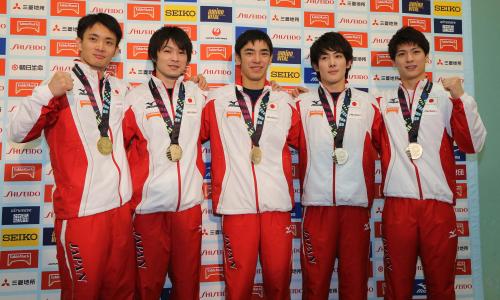 体操の世界選手権から帰国し、男子団体総合の金メダルを胸にポーズをとる（左から）田中、内村、白井、加藤、早坂