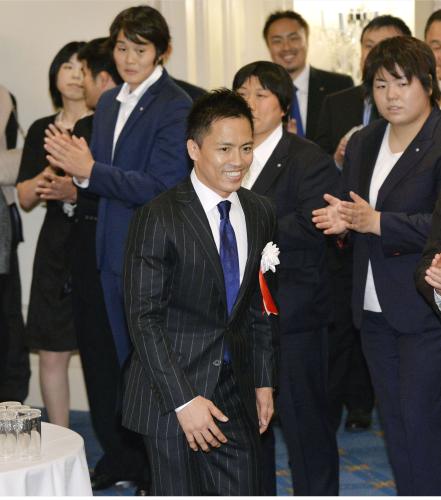 大阪市で開かれた引退報告会で、関係者に拍手で迎えられる柔道の野村忠宏さん