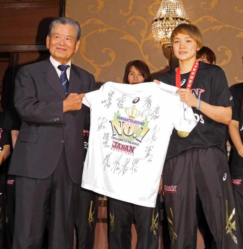 バスケットボール女子日本代表の吉田主将（右）からサイン入りＴシャツを受け取る川淵会長