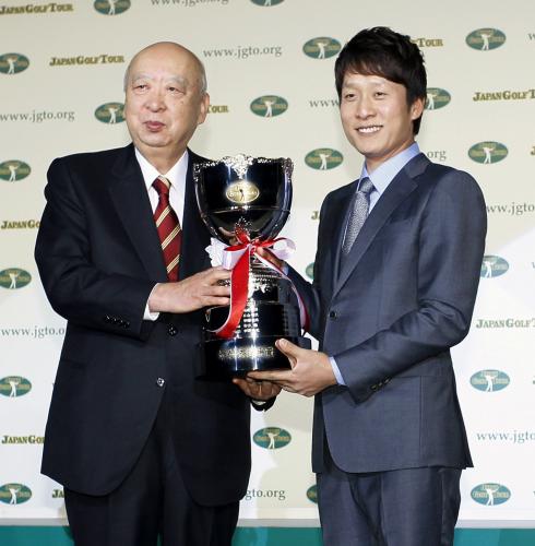 最優秀選手賞に輝き、ＪＧＴＯの海老沢勝二会長（左）から笑顔でトロフィーを受け取る金庚泰