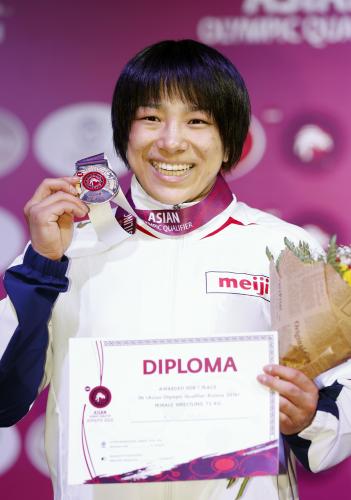女子75キロ級で優勝しメダルを手に笑顔の渡利璃穏