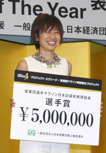 賞金ボードを手に笑顔の女子マラソンの福士加代子