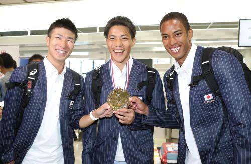 関係者からプレゼントされた金メダルを手に笑顔を見せる（左から）桐生、山県、ケンブリッジ