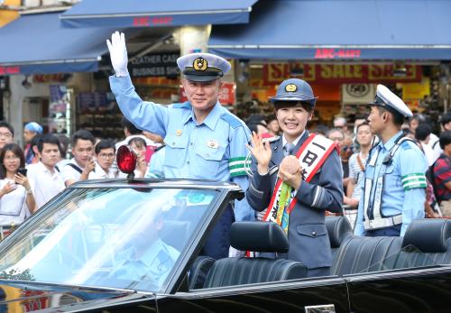 １日警察署長の福原愛（右）はリオ五輪のメダルを手に櫻井新宿署長と共に新宿駅前をパレード