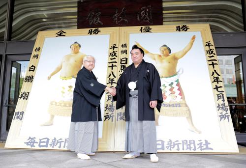 ＜優勝額贈呈式＞白鵬の代理で出席した宮城野親方（左）と握手する日馬富士