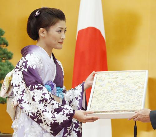 国民栄誉賞授与式で、記念品の京都・西陣産の帯を受け取るレスリング女子58キロ級の伊調馨選手