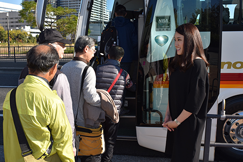 バスツアー出発時に参加者を笑顔で出迎える田中琴乃さん