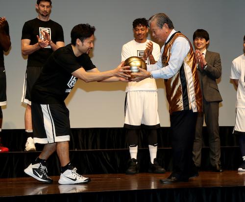 ８０歳のお祝いの金色のボールを田臥（左）から受け取る川淵三郎初代Ｂ・リーグチェアマン