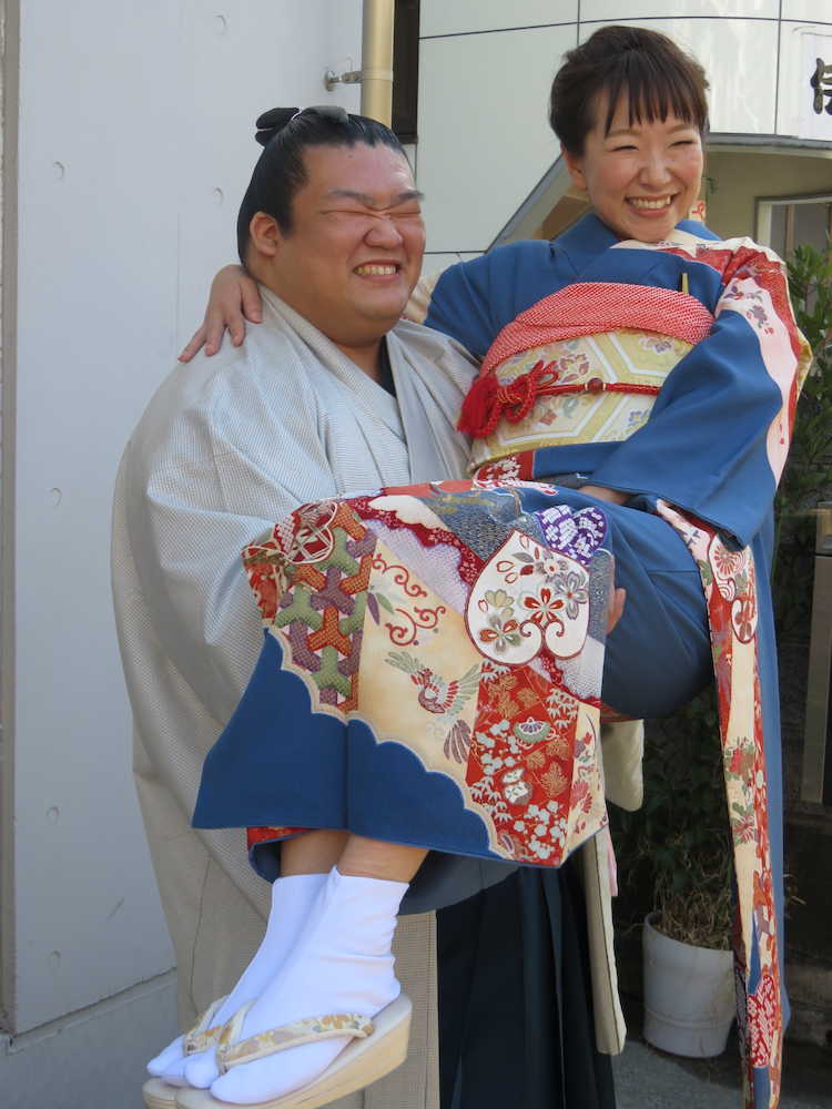 部屋前でお姫様抱っこをする誉富士と婚約者の坂田祥子さん