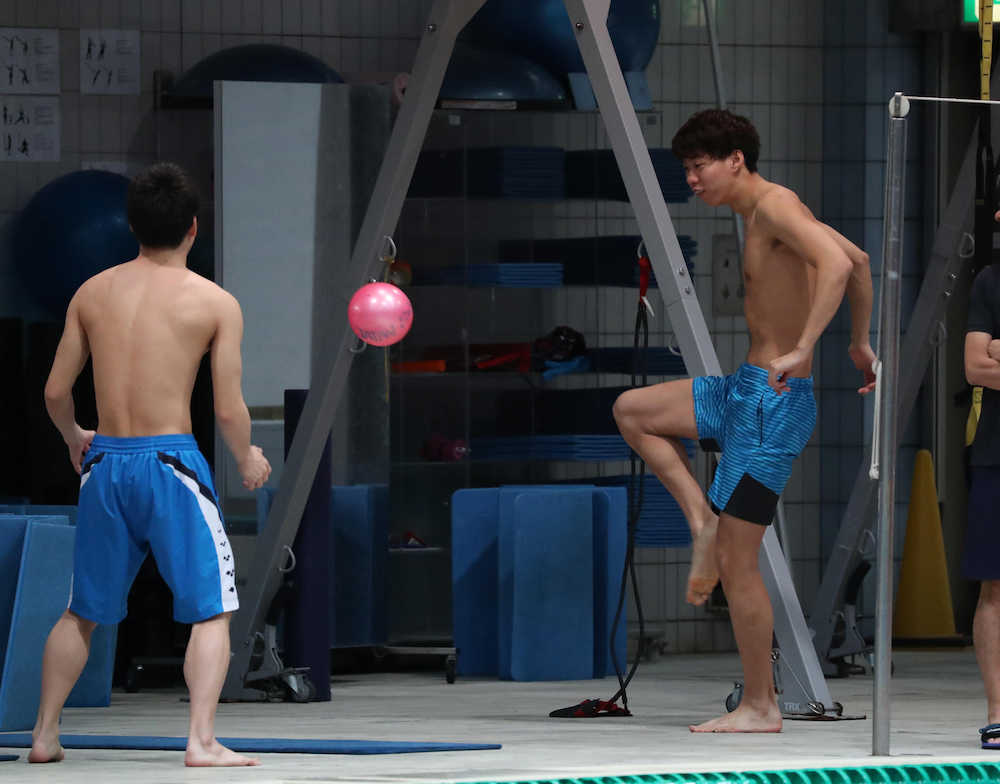 ＜競泳日本代表練習公開＞リフティングで体をほぐす渡辺一平（右）