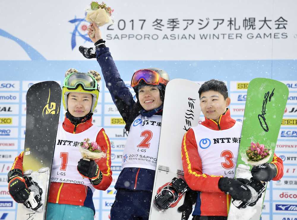 冬季アジア大会スノーボード女子大回転で優勝し、フラワーセレモニーで喜ぶ家根谷依里（中央）