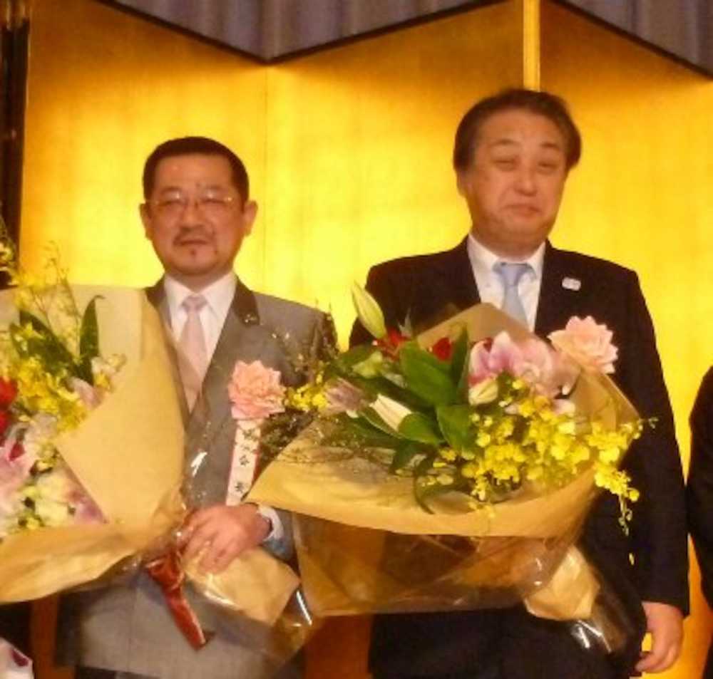 全日本空手道一友会創立４０周年祝賀会で花束を贈呈された小原博会長（左）と野口正行名誉会長
