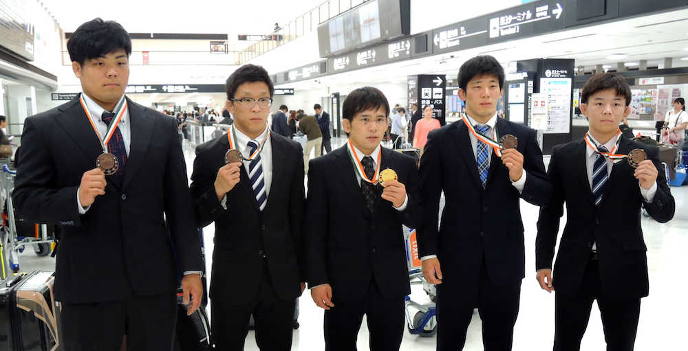 レスリングのアジア選手権から帰国し、メダルを手にポーズをとる（左から）山本泰輝、鴨居正和、高橋侑希、中村百次郎、樋口黎