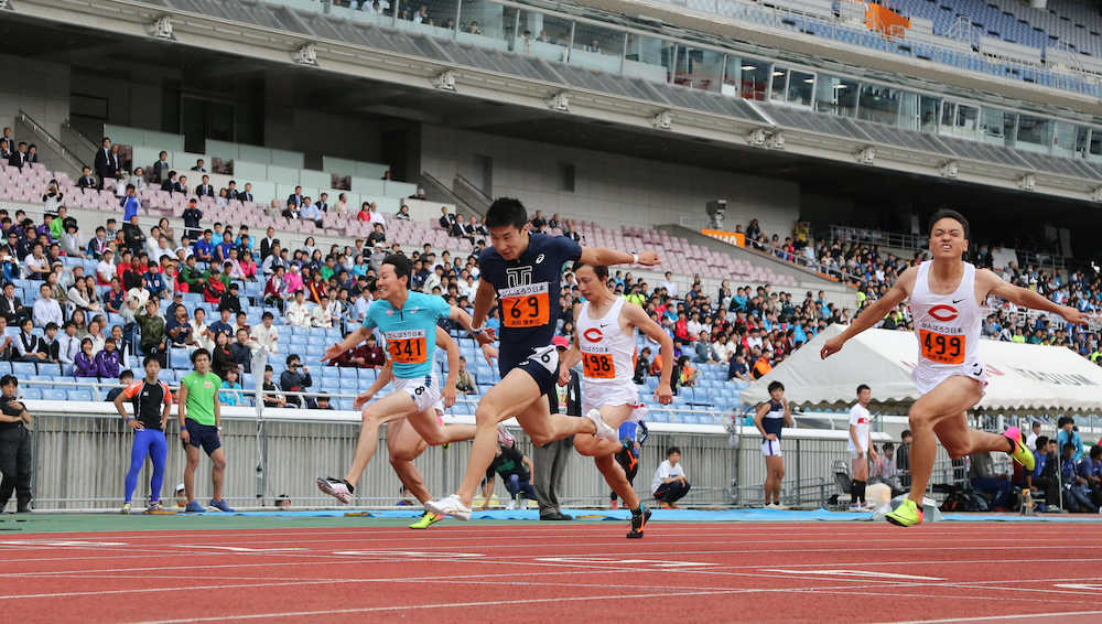 男子１００メートル決勝、優勝する桐生（中央）