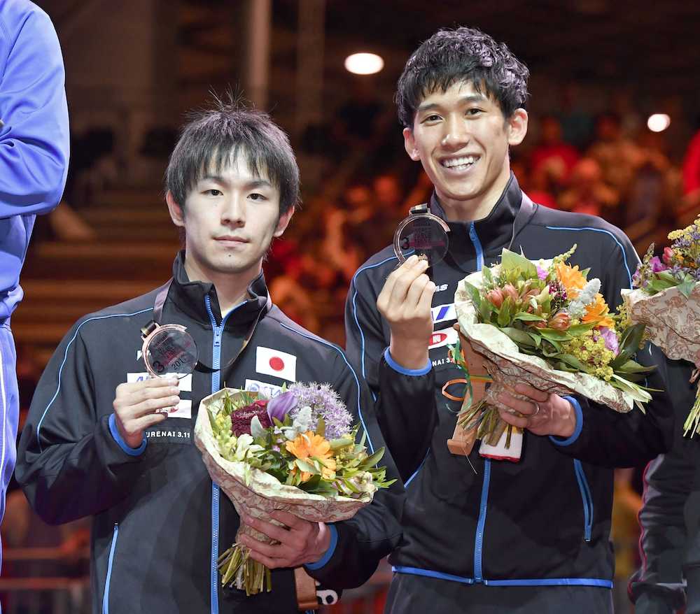 男子ダブルスで銅メダルを獲得し、表彰台でメダルを手にする丹羽（左）、吉村組