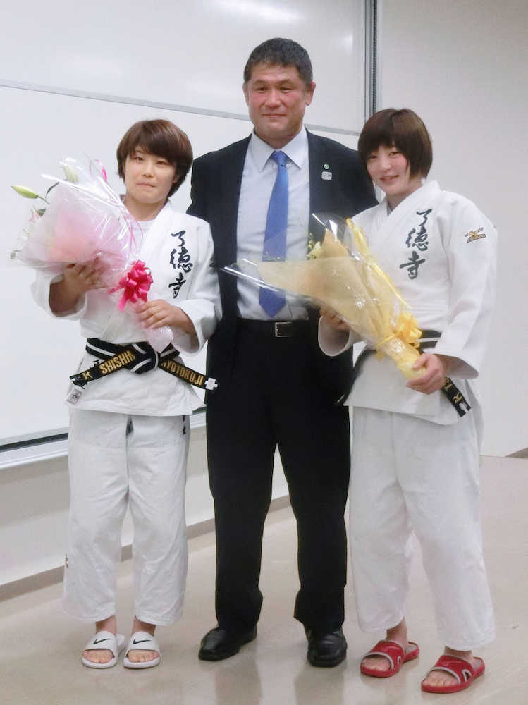 了徳寺学園の壮行会で花束を手にする志々目（左）と角田。中央は山田監督