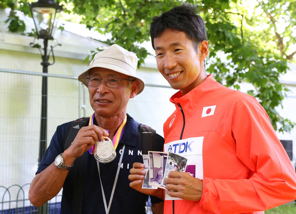 男子５０キロ競歩、父・康行さんに銀メダルを掛け、亡き母・繁美さんの写真を手に笑顔を見せる荒井（右）