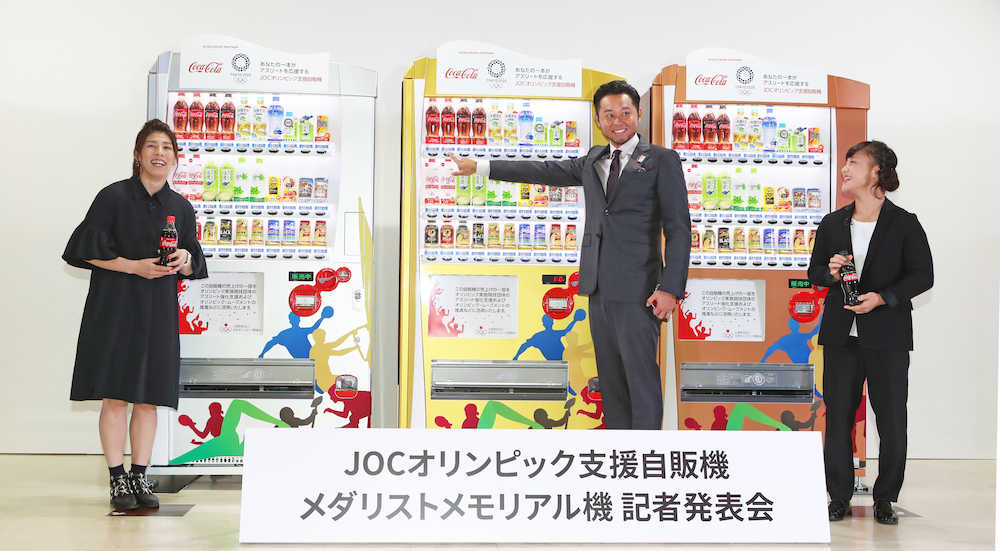 自販機の前で購入第１号となった（左から）吉田沙保里、北島康介氏、登坂絵莉