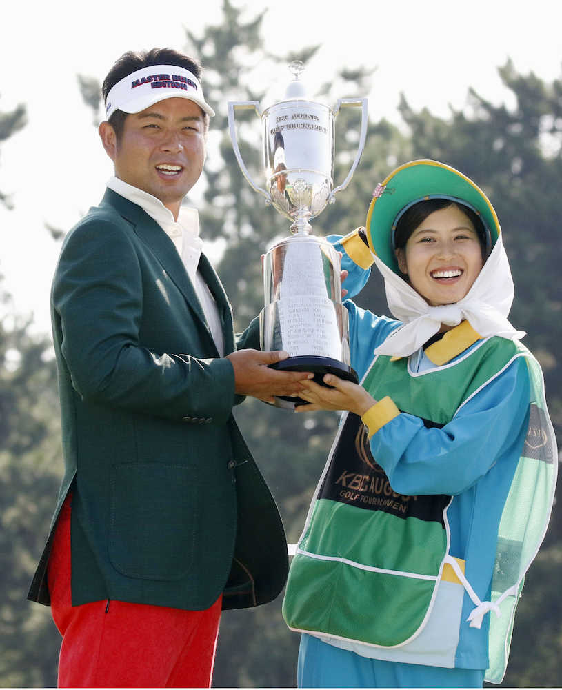 ハウスキャディーの山崎さん（右）と優勝カップを手に笑顔を見せる池田勇太