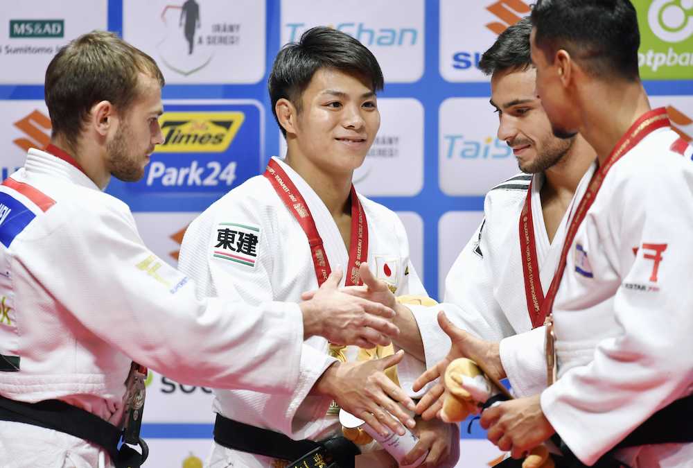 世界柔道男子６６キロ級で初優勝し、表彰台で握手を交わす阿部（左から２人目）