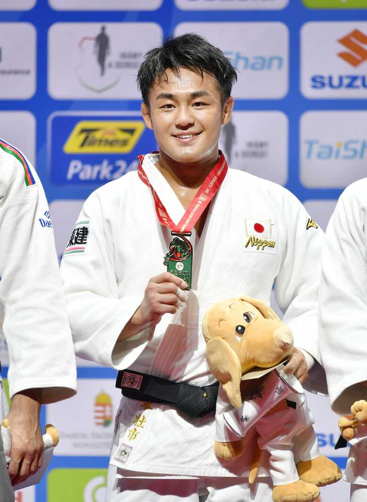柔道の世界選手権男子７３キロ級で優勝し、獲得したメダルを手に笑顔の橋本壮市