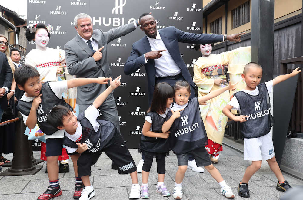 ウブロブティック京都の開店イベントに登場したウサイン・ボルト氏は、グアダルーペＣＥＯ、舞妓さん、子どもたちと一緒に「ライトニング　ボルト」ポーズ