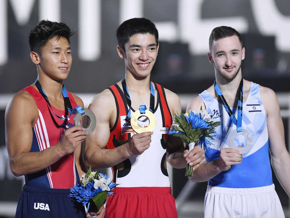 体操の世界選手権男子種目別床運動で優勝し、金メダルを手にする白井健三（中央）