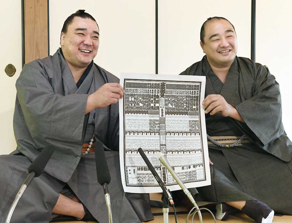 大相撲九州場所の番付表を手に笑顔を見せる横綱日馬富士（左）と幕内に返り咲いた安美錦