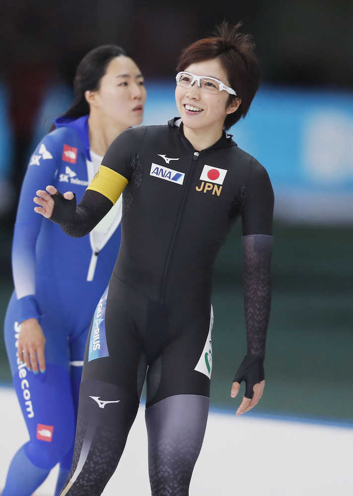 女子５００メートルで優勝し笑顔を見せる小平（右）。この種目で２０レース無敗となった。後方は韓国の李相花