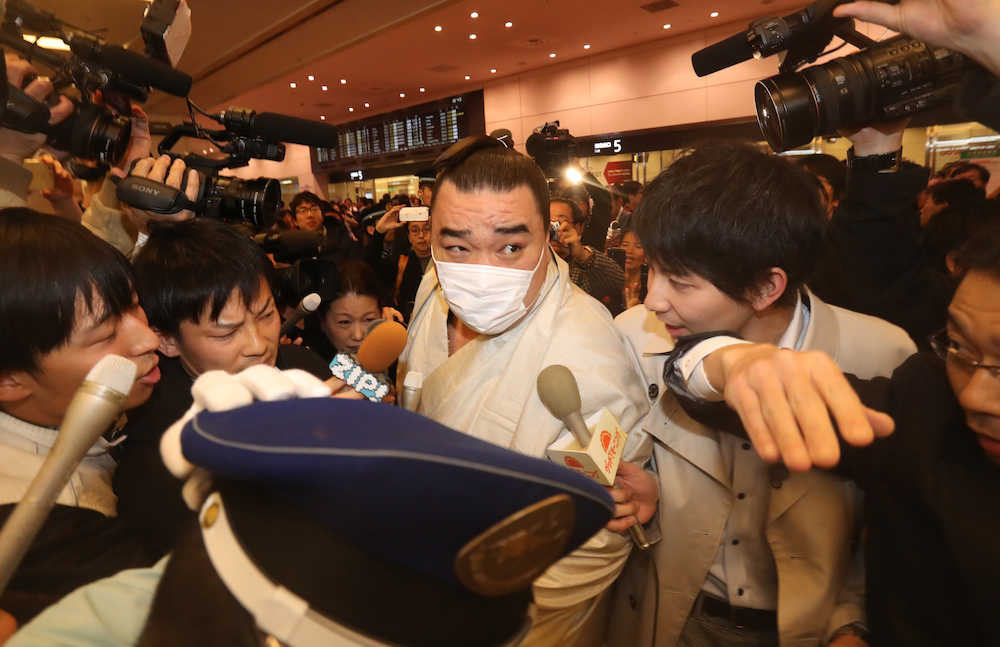 会見終え羽田空港に到着、報道陣に囲まれ移動する日馬富士