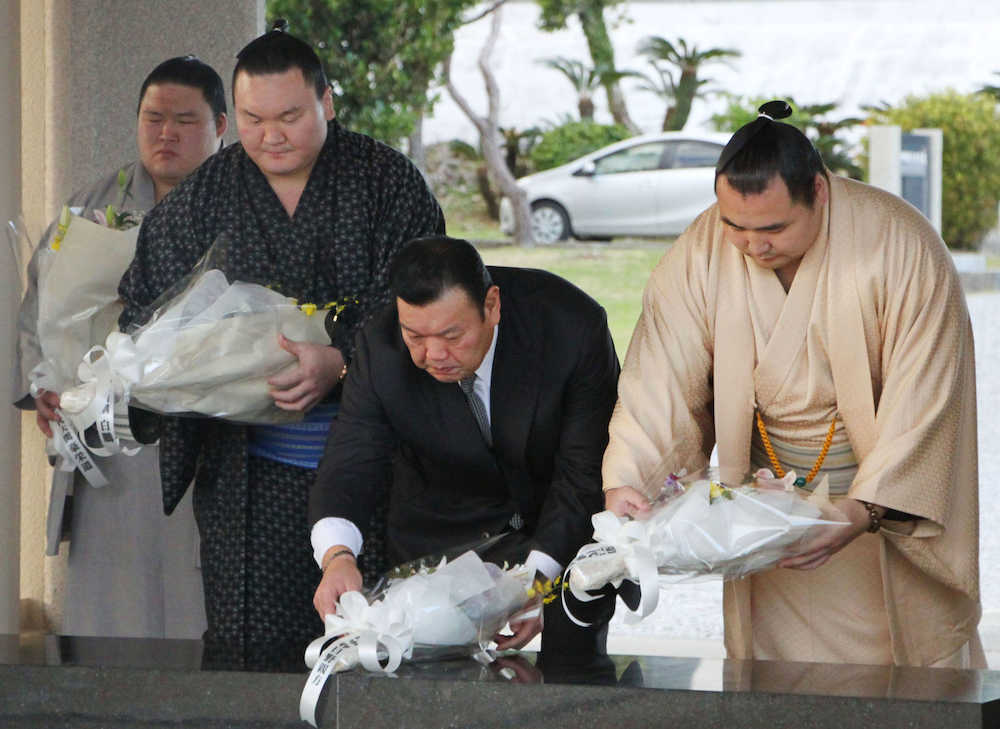 糸満市の平和祈念公園で献花する（右から）鶴竜関、春日野広報部長、白鵬関