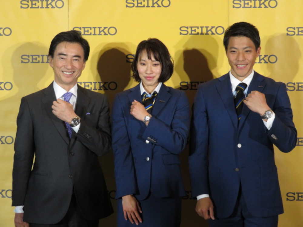 腕時計を見せながら記念撮影に応じる（左から）服部ＣＥＯ、福島、山県