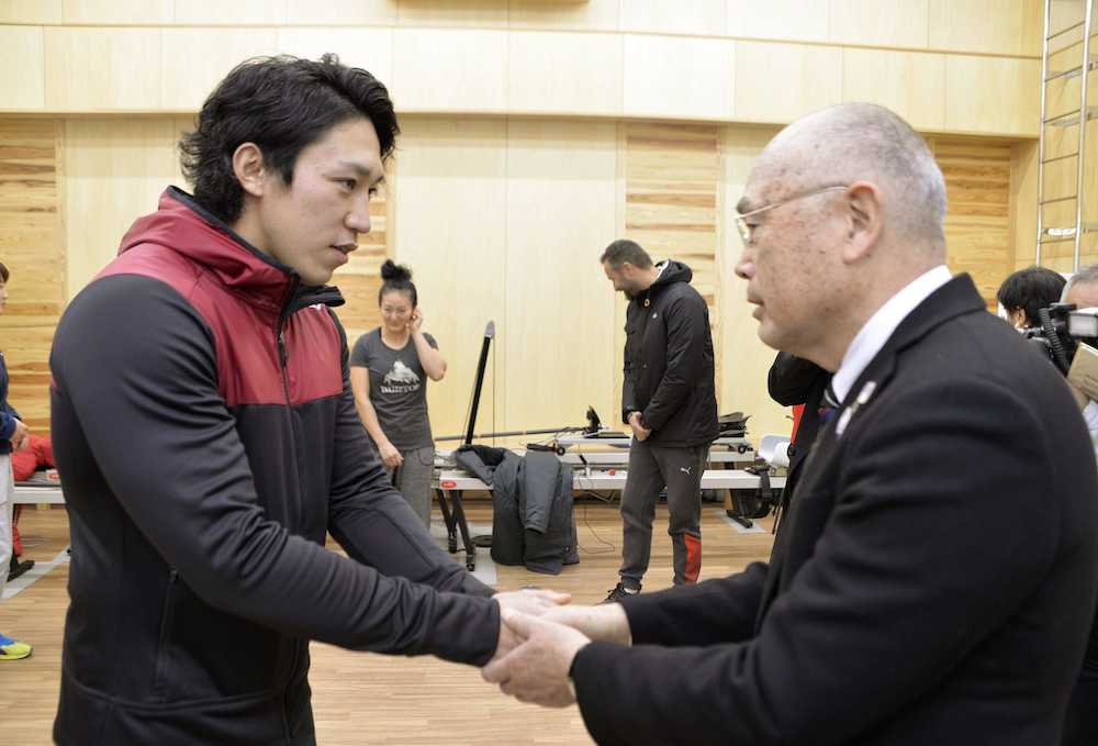 日本カヌー連盟の成田会長（右）と握手する小松